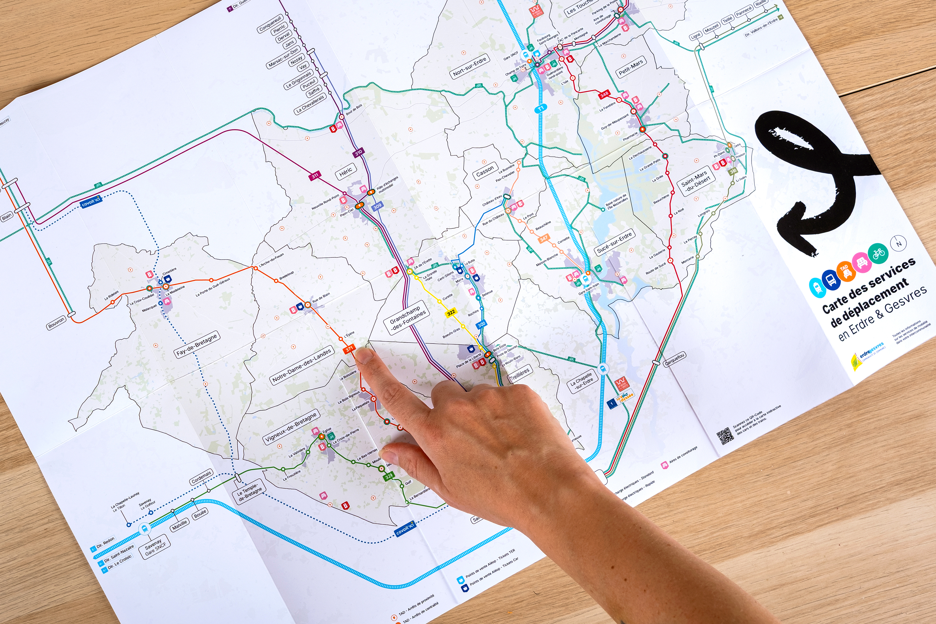 Doigt pointant une destination sur la carte des services de déplacement en Erdre & Gesvres
